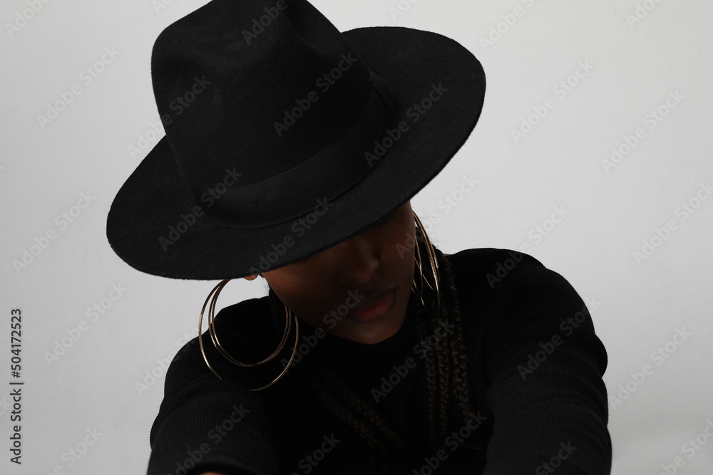 Portrait of African American woman wearing black hat posing on white background. Portrait of African American woman wearing black hat posing on white background.