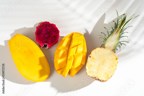 Assorted various tropical Asian fruits. Mango, pineapple, pitahaya, whole and cut, on a white background.
