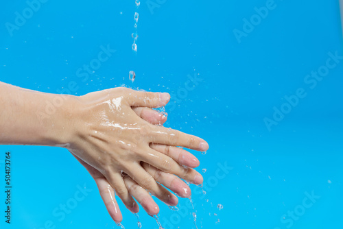 Washing hands with water on blue background