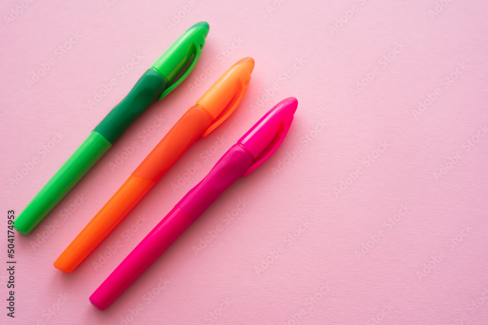 top view of colorful and bright pens on pink. top view of colorful and bright pens on pink.