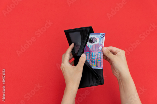 Woman hand holding a wallet with Hong Kong Dollar