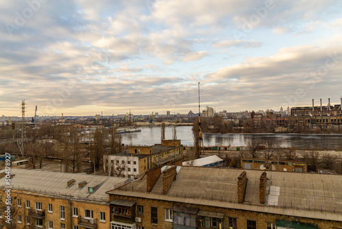 Kyiv, Ukraine – February 06, 2016: A beautiful panorama of Podil region during sunset. Aerial view on residential and industrial areas. Different architectural style. Historical area, Dnipro river.
