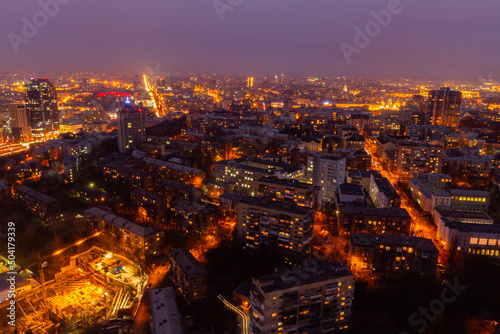 Ukraine, Kyiv – March 12, 2016: Aerial panoramic view on central part of Kyiv city from a roof of a high-rise building. Night life in a big city. Foggy and rainy weather. 