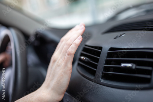 woman adjusting the cooling inside her car, Closeup of hand driver checking adjusting air from conditioning the cooling system with flow of cold air in car.