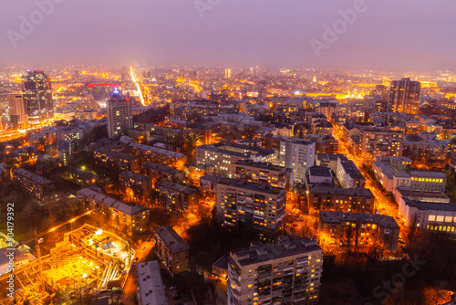 Ukraine, Kyiv – March 12, 2016: Aerial panoramic view on central part of Kyiv city from a roof of a high-rise building. Night life in a big city. Foggy and rainy weather.  photo