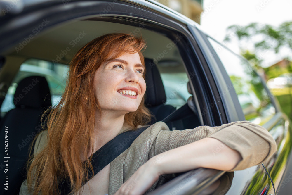 Beautiful young woman driving her new car at sunset. Woman in car. Close up portrait of pleasant looking female with glad positive expression, woman in casual wear driving a car Beautiful young woman driving her new car at sunset. Woman in car. Close up portrait of pleasant looking female with glad positive expression, woman in casual wear driving a car