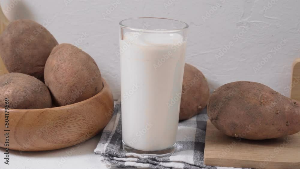 Alternative vegetable vegan potato milk in a glass and potato. Vegetarian food. Alternative non dairy drink