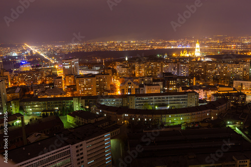 Ukraine, Kyiv – March 12, 2016: Aerial panoramic view on central part of Kyiv city from a roof of a high-rise building. Night life in a big city. Foggy and rainy weather. 