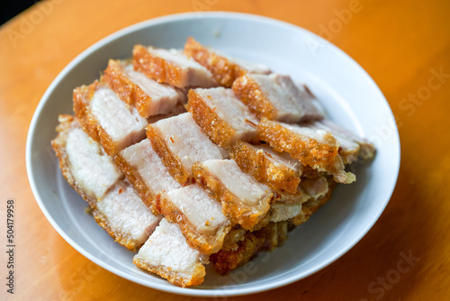 Close-up of a plate of golden and attractive crispy roasted pork, with meat