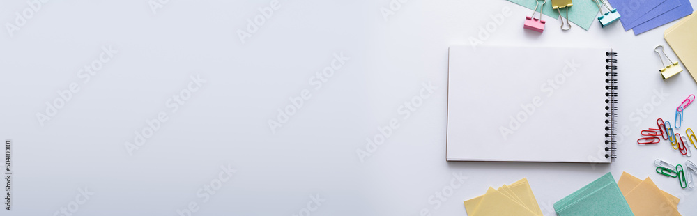 top view of blank notebook near colorful stationery on white, banner. - obrazy, fototapety, plakaty 