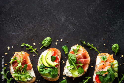 Canvastavla Open sandwiches set with cream cheese, prosciutto, salmon, avocado and fresh greens and vegetables