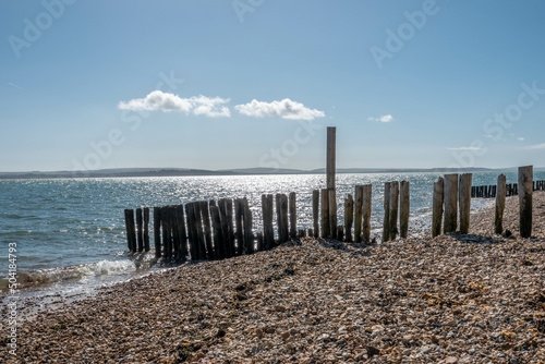 old wooden groynes on a deserted English beach on a bright sunny spring day