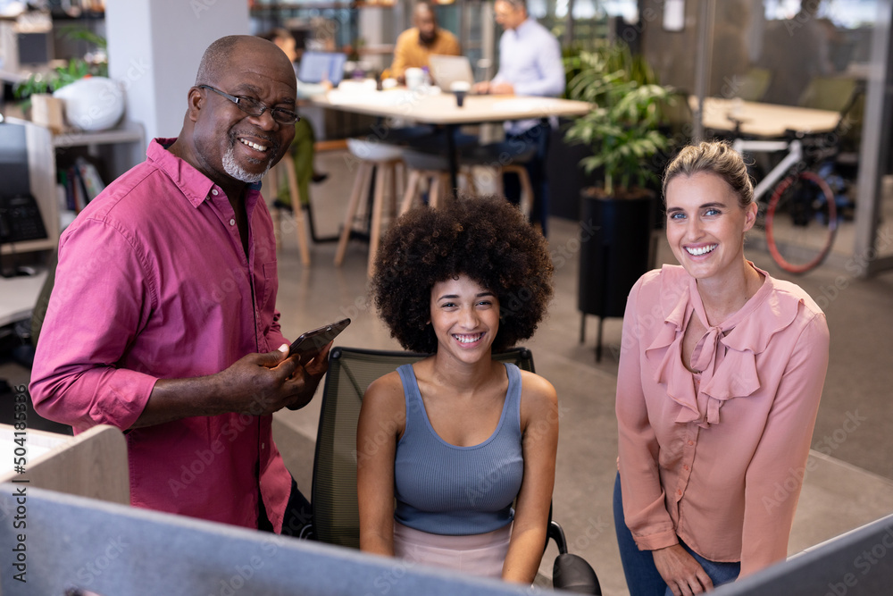 Portrait of happy multiracial businessman and businesswomen working together at modern workplace