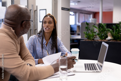 Young biracial businesswoman planning strategy with african american businessman at modern workplace