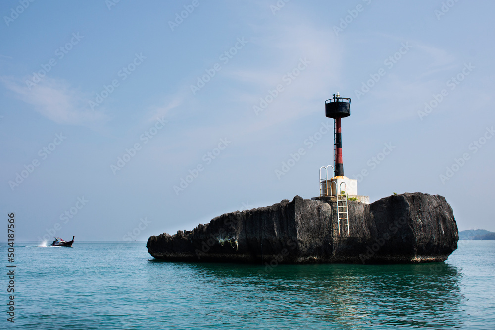 Classic vintage lighthouse or beacon in sea ocean for security protection of fishing boat and fishery ship sailing at Mu Ko Petra National Park in Pak Bara waterfront at La ngu city in Satun, Thailand