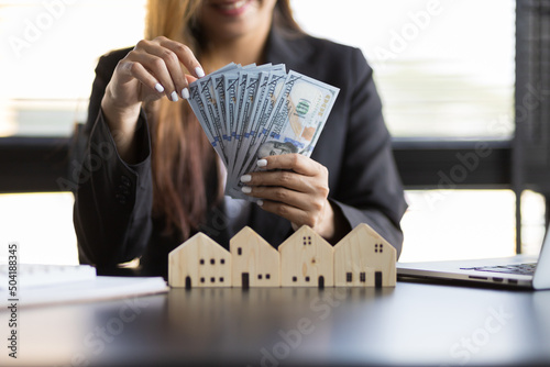 Real estate agent businesswoman counting cash, deposit or commission on real estate sales. photo