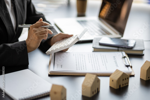 Home rental ideas, loans, mortgages and real estate valuations for sale. Businesswoman in a bank office is calculating a mortgage.
