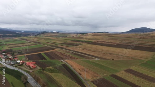 Flyover above beautiful fields, farmland around Sancraieni, Romania. Ciuc Mountain range photo