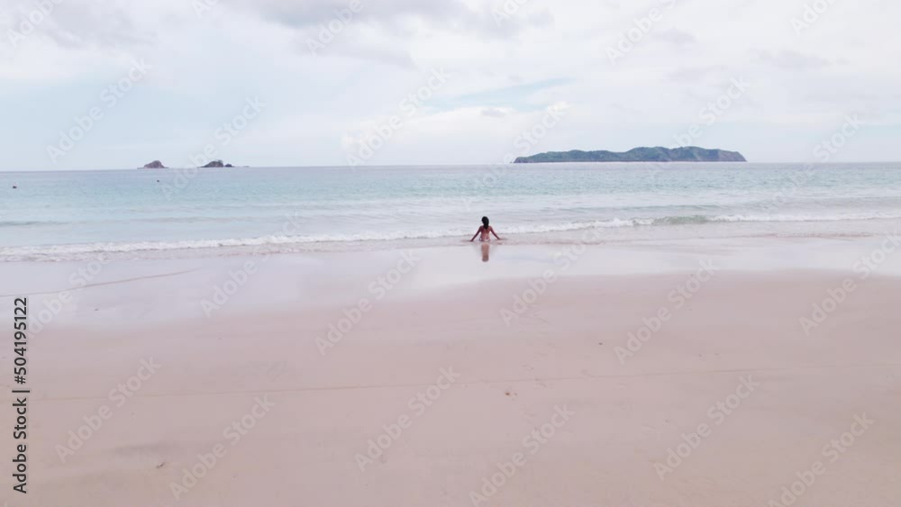 Drone Ofwoman Sitting In Sea On Nacpan Beach Drone Ofwoman Sitting In Sea On Nacpan Beach
