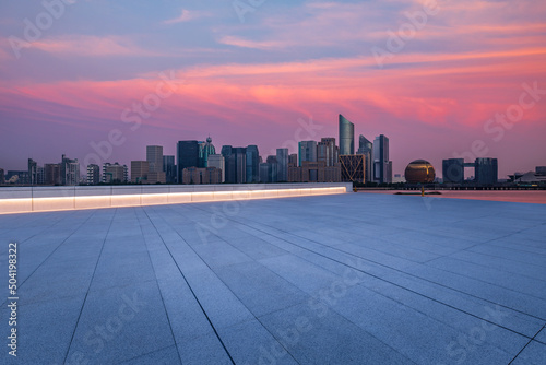 Empty square floor and city skyline with modern commercial buildings in Hangzhou at night, China.