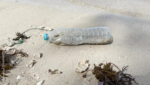 Plastic Bottle and Seaweed on the Sand