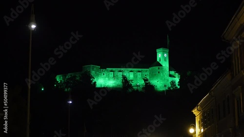 Shot of Ljubljana castle from city Centre at night, Slovenia. View of castle with green lights. photo