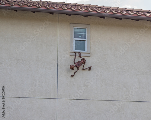 Outdoor Halloween climbing  creature on the wall.
