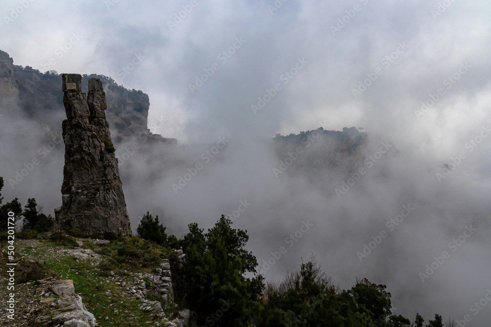 A pinnacle like rock formation on the famous Path of the Gods (Sentiero Degli Dei) on the Amalfi Coast in Campania, Italy, Europe. Hiking trail to San Lazzaro is covered with mystical fog.