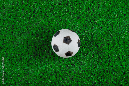 Top view of soccer ball on green grass field.