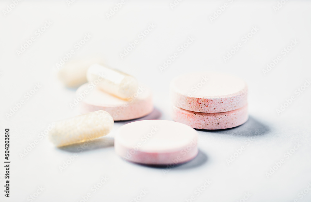 Collagen effervescent Tablets and Vitamin C capsules. Supplements to support collagen production. Bright paper background. Soft focus. Close up. Collagen effervescent Tablets and Vitamin C capsules. Supplements to support collagen production. Bright paper background. Soft focus. Close up.