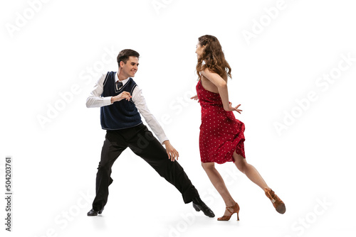 Beautiful girl and stylish man in vintage retro style outfits dancing isolated on white background. Timeless traditions, 60s,70s american fashion style and art