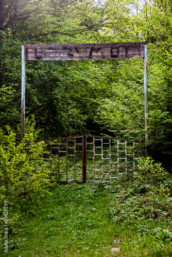 old rusty gate with a wooden sign in the Carpathian forest