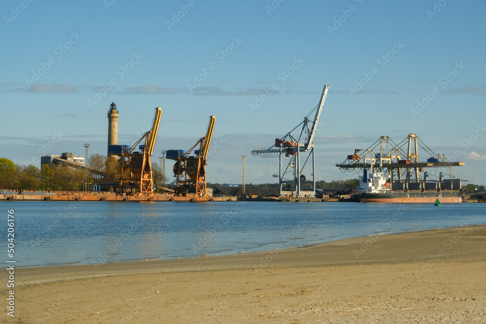 industrial area on the coast. big cranes in the background. port