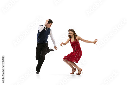 Beautiful girl and stylish man in vintage retro style outfits dancing isolated on white background. Timeless traditions, 60s,70s american fashion style and art