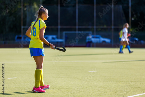 Young field hockey female player with stick during the game. Image with copy space