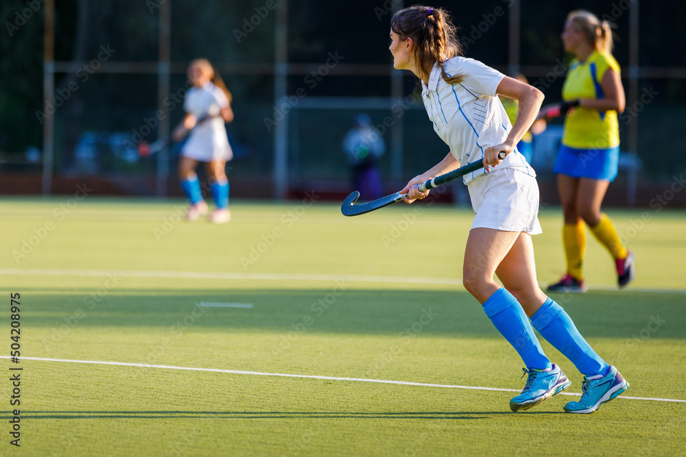 Young field hockey female player with stick during the game. Image with copy space