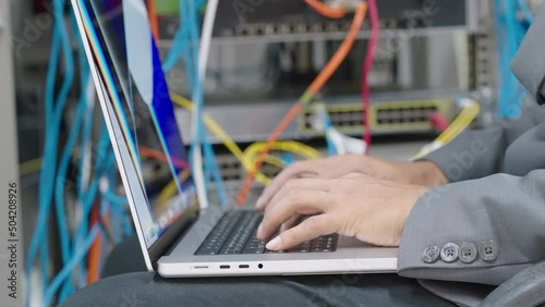 Male administrator it engineer conducts maintenance work in secure server room of cyberspace photo