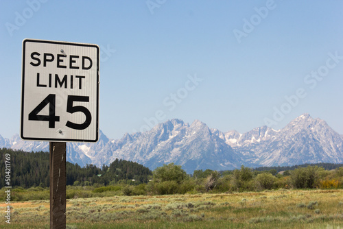 Verkehrsschild in Amerika mit Tempolimit fünfundvierzig. Verkehrszeichen in Front einer Gebirgskette aus dem National Park Great Teton in den USA. © languste15