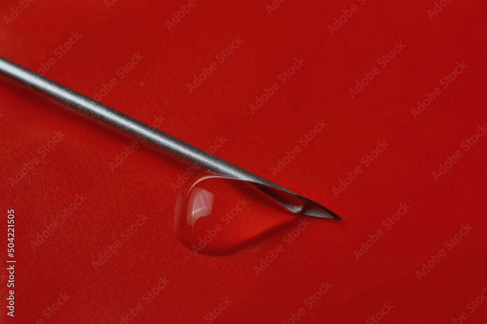 Syringe needle and a drop of a transparent substance. close-up Syringe needle and a drop of a transparent substance. close-up