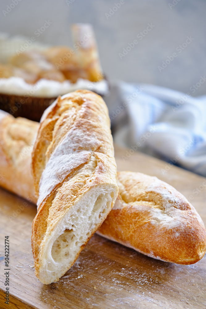 Fresh baguette with crispy crust on a wooden board close -up