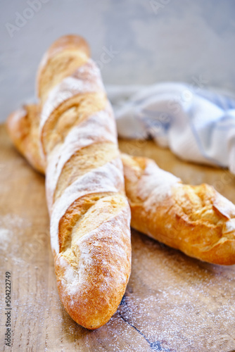 Fresh baguette with crispy crust on a wooden board close -up © Tereza