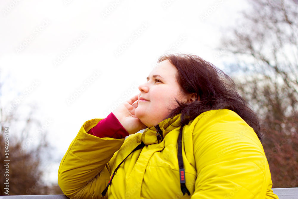 Attractive chubby overweight Caucasian woman smiling portrait outdoors with copy space. Cheerful pretty body positive person during walk in the park. Attractive chubby overweight Caucasian woman smiling portrait outdoors with copy space. Cheerful pretty body positive person during walk in the park.