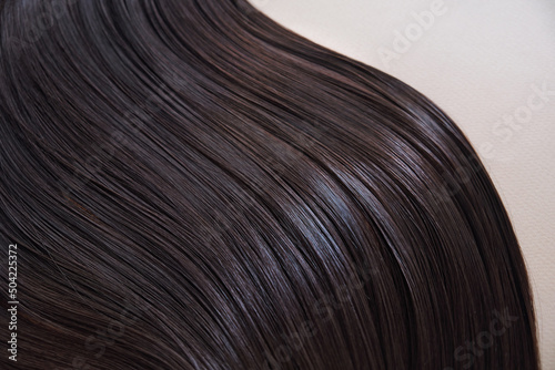 texture of well-groomed beautiful hair. Concept hairdresser spa salon. strand of brunette silky hair.