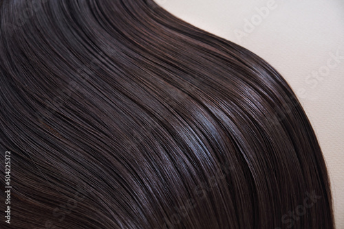 texture of well-groomed beautiful hair. Concept hairdresser spa salon. strand of brunette silky hair. photo