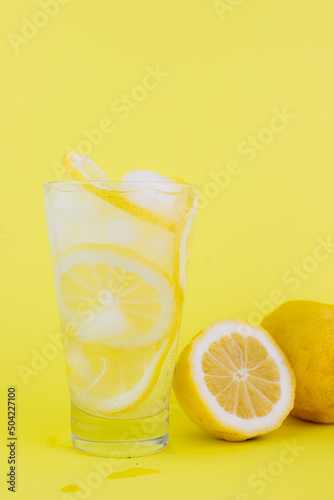 lemonade with lemons and ice on a yellow background