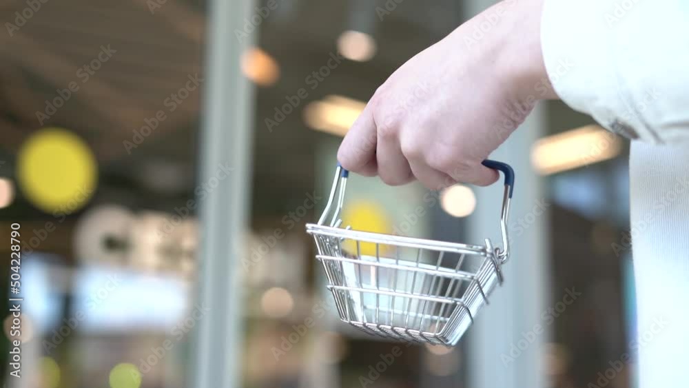 Woman holding empty shopping basket. Women carrying full shopping basket in grocery store. A woman is holding the empty basket in super market Woman holding empty shopping basket. Women carrying full shopping basket in grocery store. A woman is holding the empty basket in super market