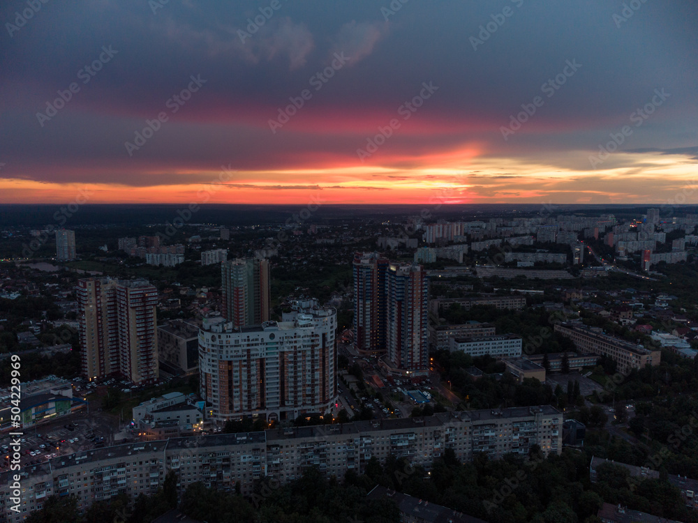 Vibrant sunset aerial view in city modern residential multistory district. 23 serpnia, Pavlovo Pole, Kharkiv, Ukraine. Fly at dusk, evening cloudscape and summer streets