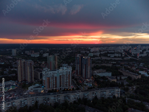 Vibrant sunset aerial view in city modern residential multistory district. 23 serpnia, Pavlovo Pole, Kharkiv, Ukraine. Fly at dusk, evening cloudscape and summer streets