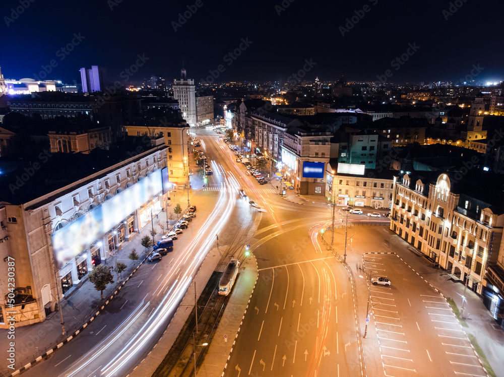 Night city center transport driveway aerial view with long exposure. Pavlivska Square in lights illumination. Downtown streets in Kharkiv, Ukraine