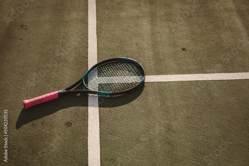 High angle view of tennis racket on white lines at tennis court during sunset, copy space